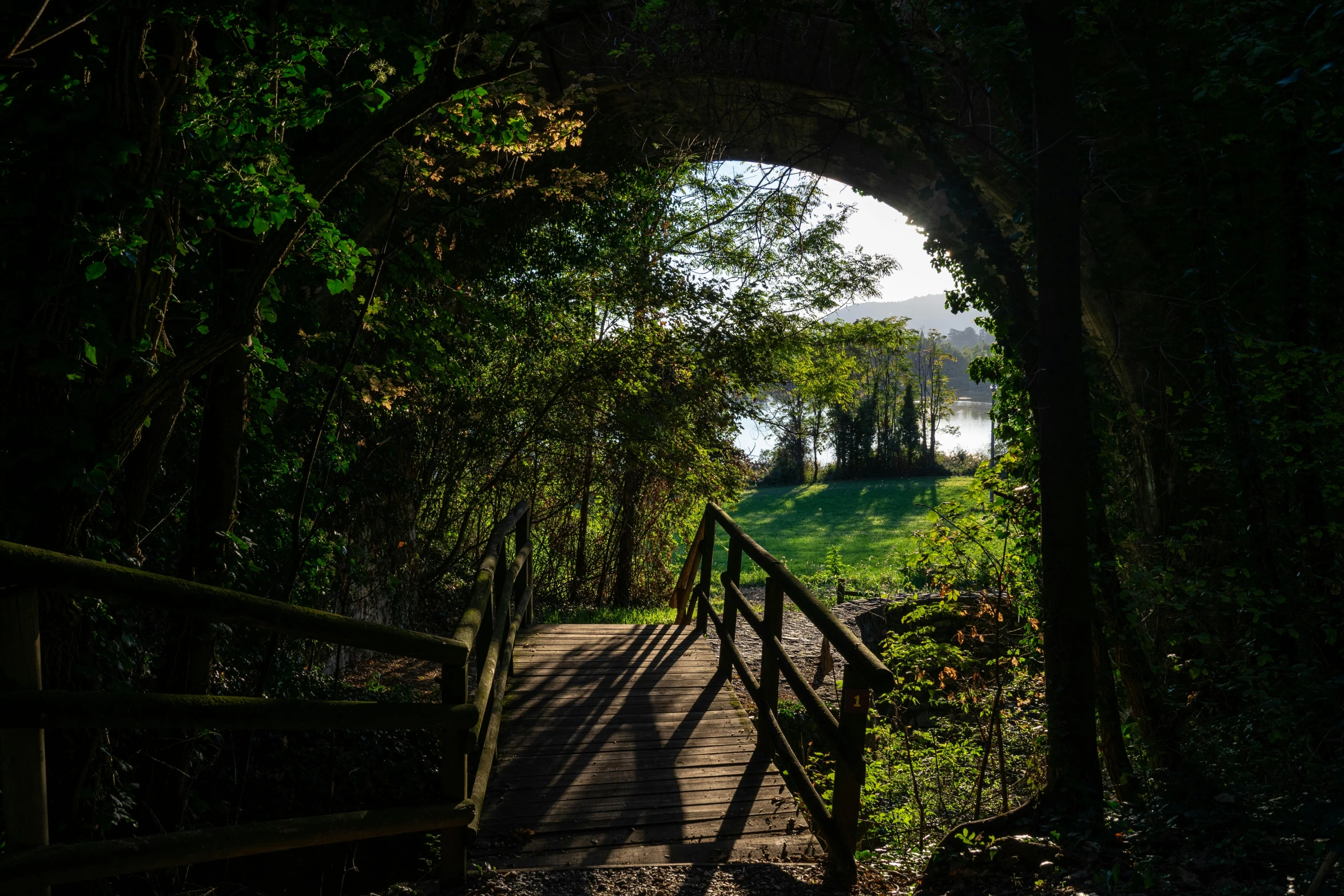 the entrance to a park with a wooden fence