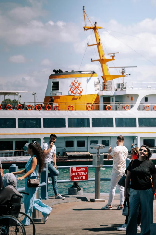 some people walking around in front of a large boat