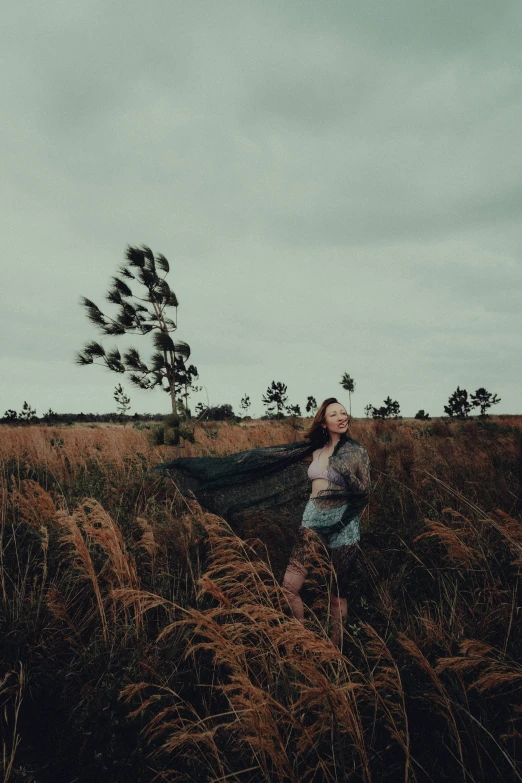 a woman in blue standing on a grass field