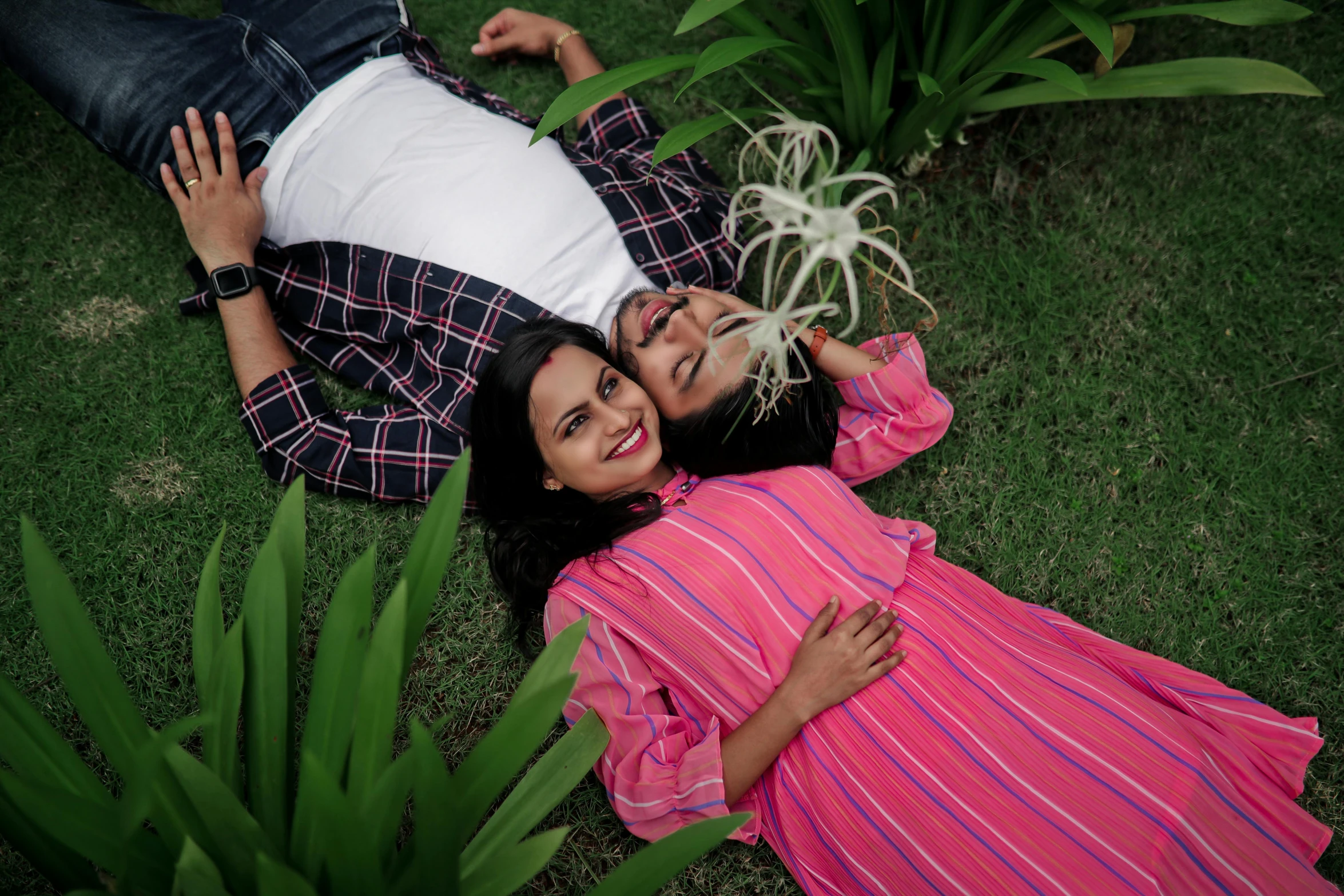 a couple is laying in the grass together