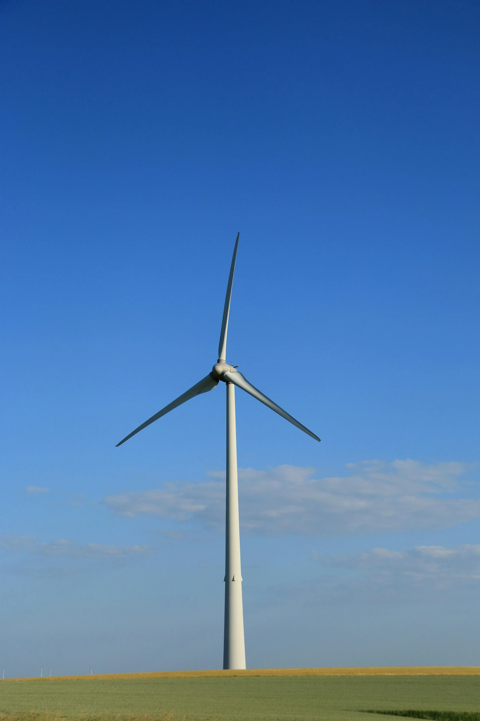 a wind turbine in a field with a clear blue sky