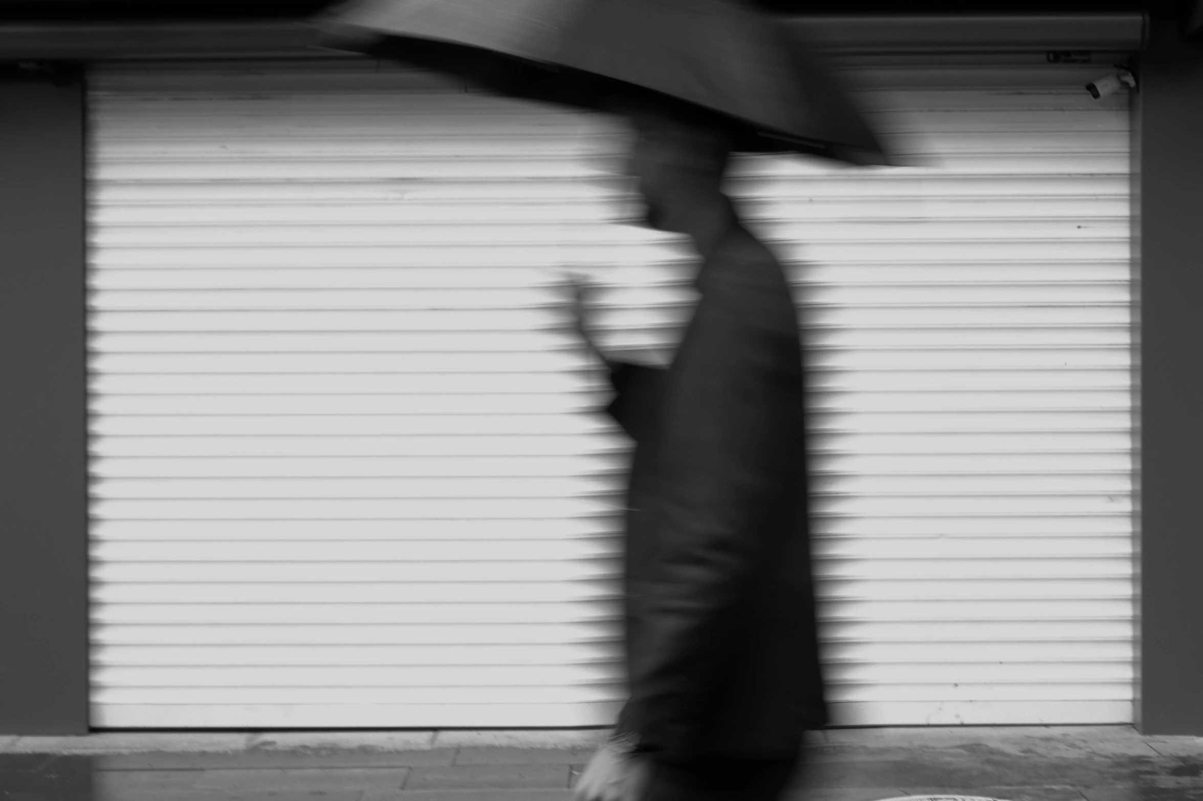 a man is walking away holding an umbrella