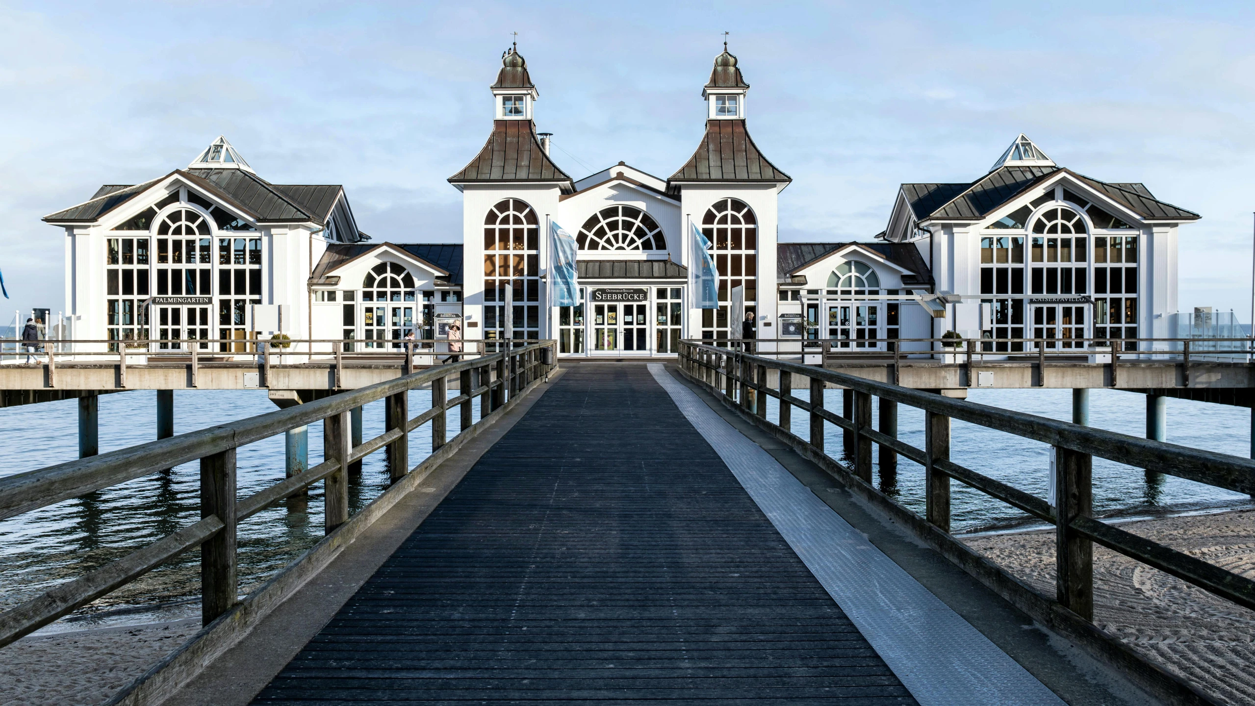 a wooden dock with white and gray buildings on top of it