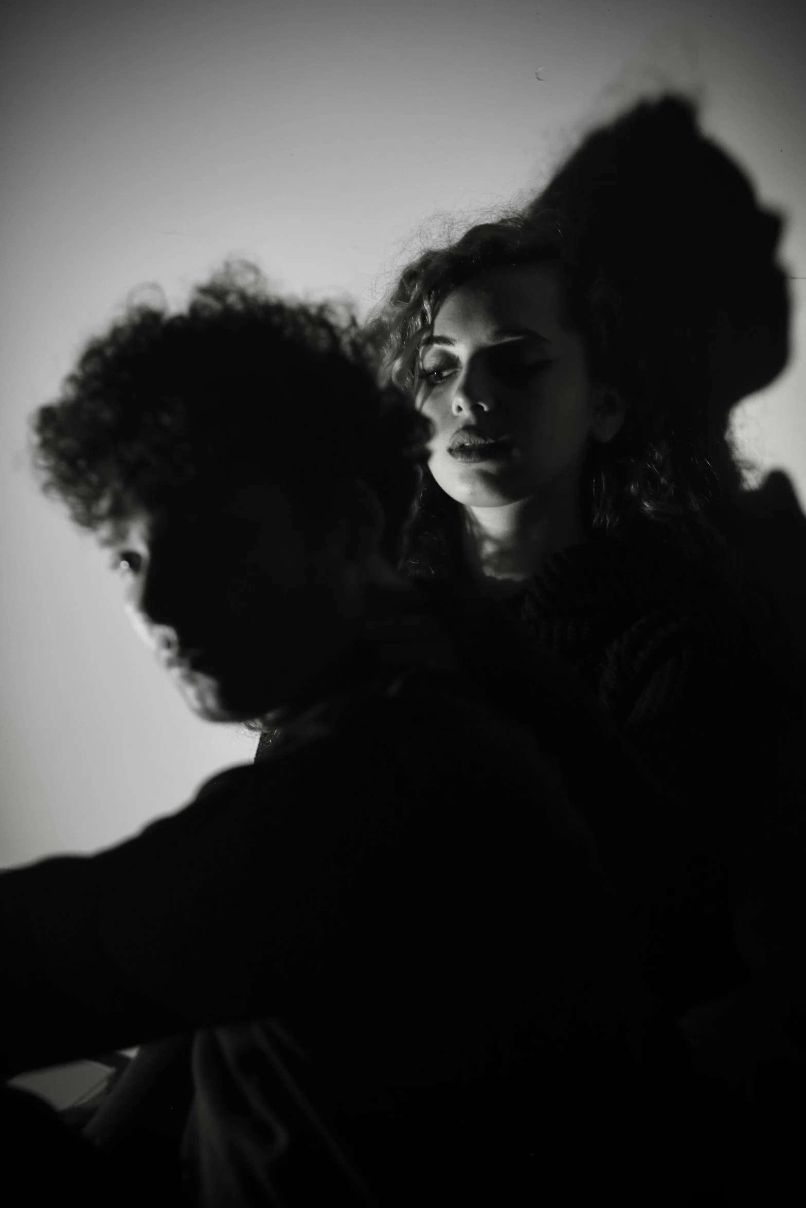 a woman with curly hair is shown leaning against the back of a man