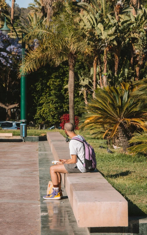 a person sitting on a bench in a park