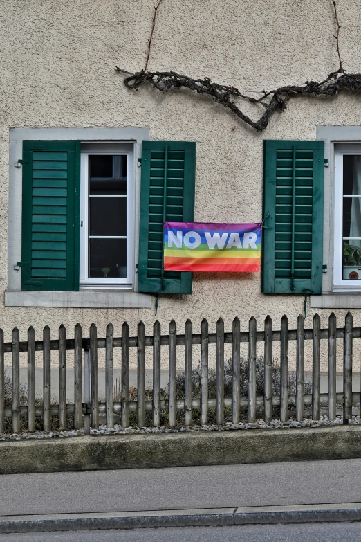 a rainbow sign hanging on the side of a building