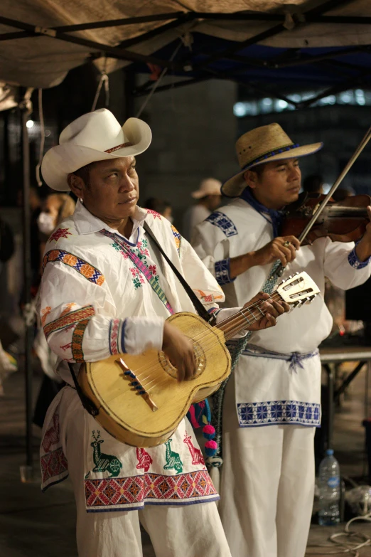 a group of people in white outfits are playing instruments