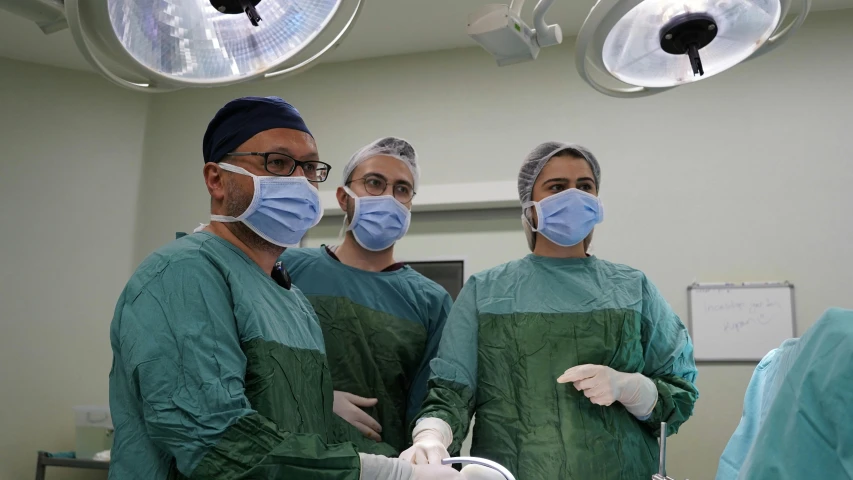 three doctors in scrubs stand next to each other