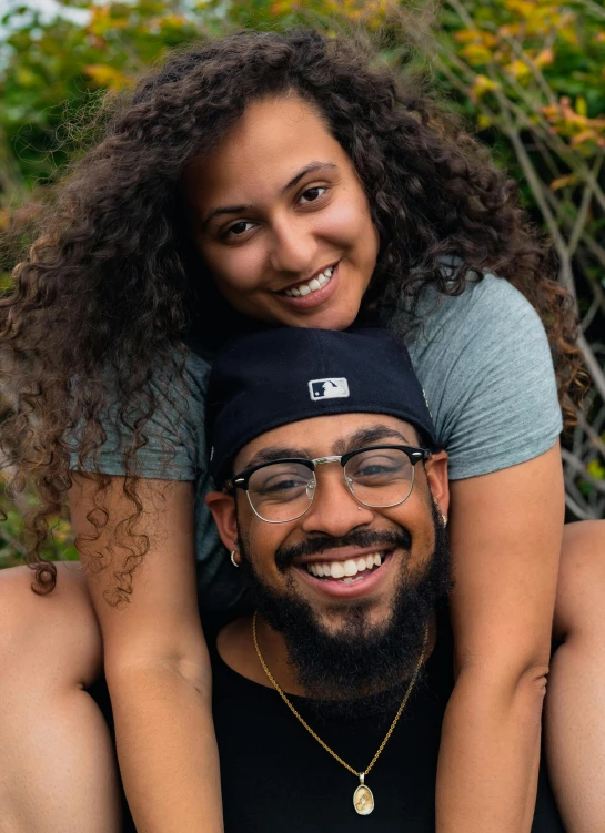 a man and woman, both wearing glasses, smiling