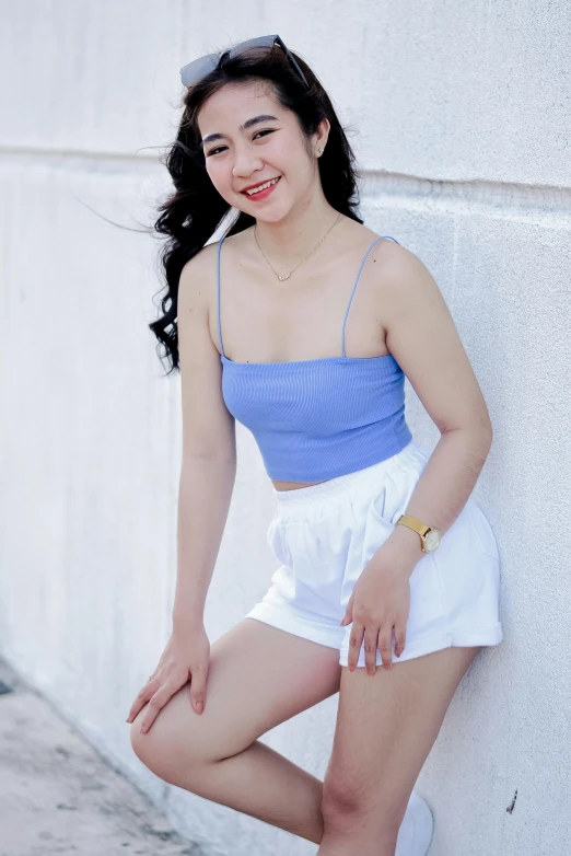 an asian girl with long black hair, wearing shorts and a blue top