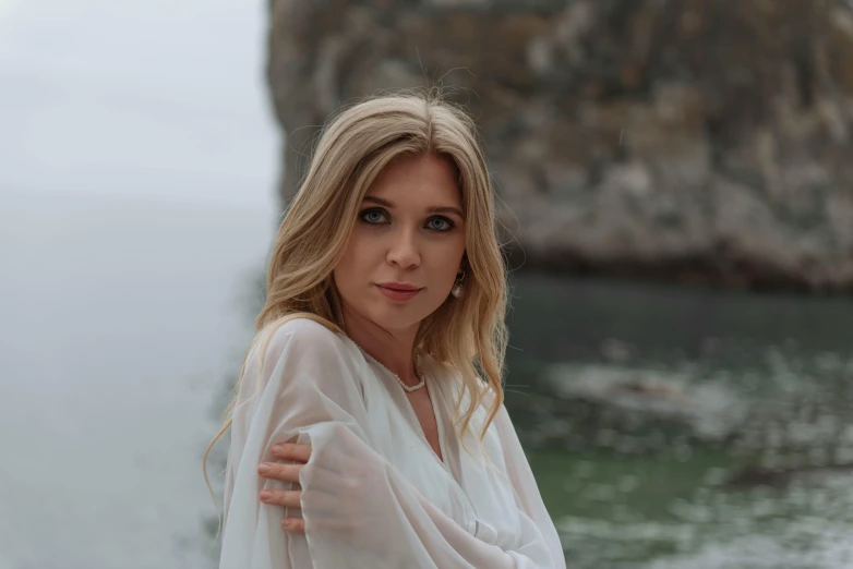 a woman standing in front of a body of water