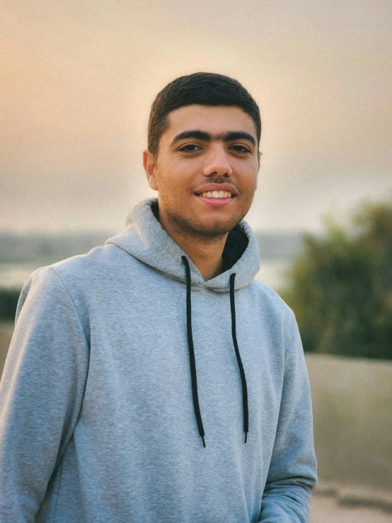 a young man standing outside with a skateboard