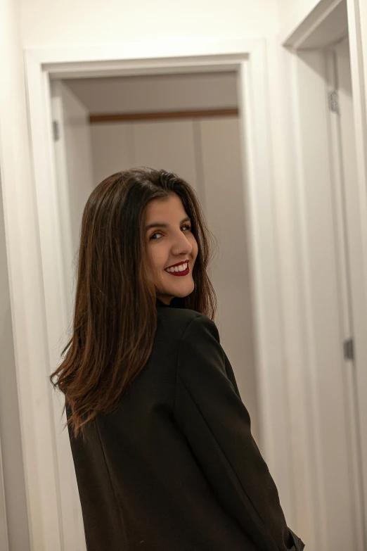 a woman is standing in front of a door with her long hair in ponys