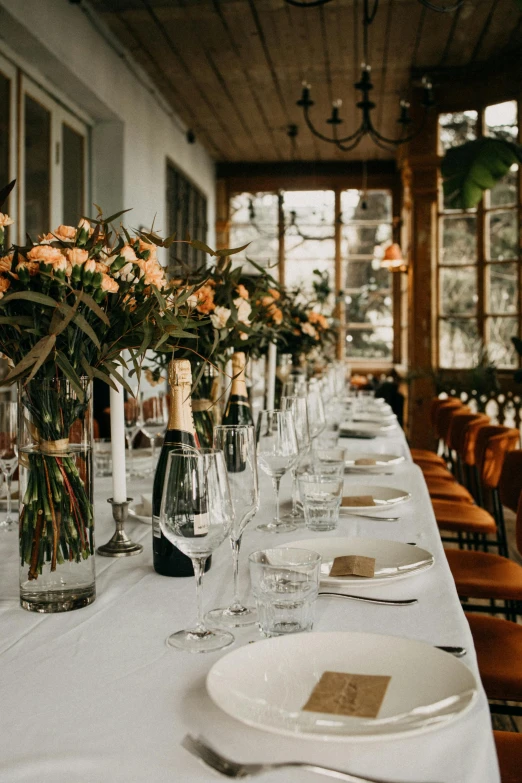 tables laid out with plates, silverware and bottles of wine