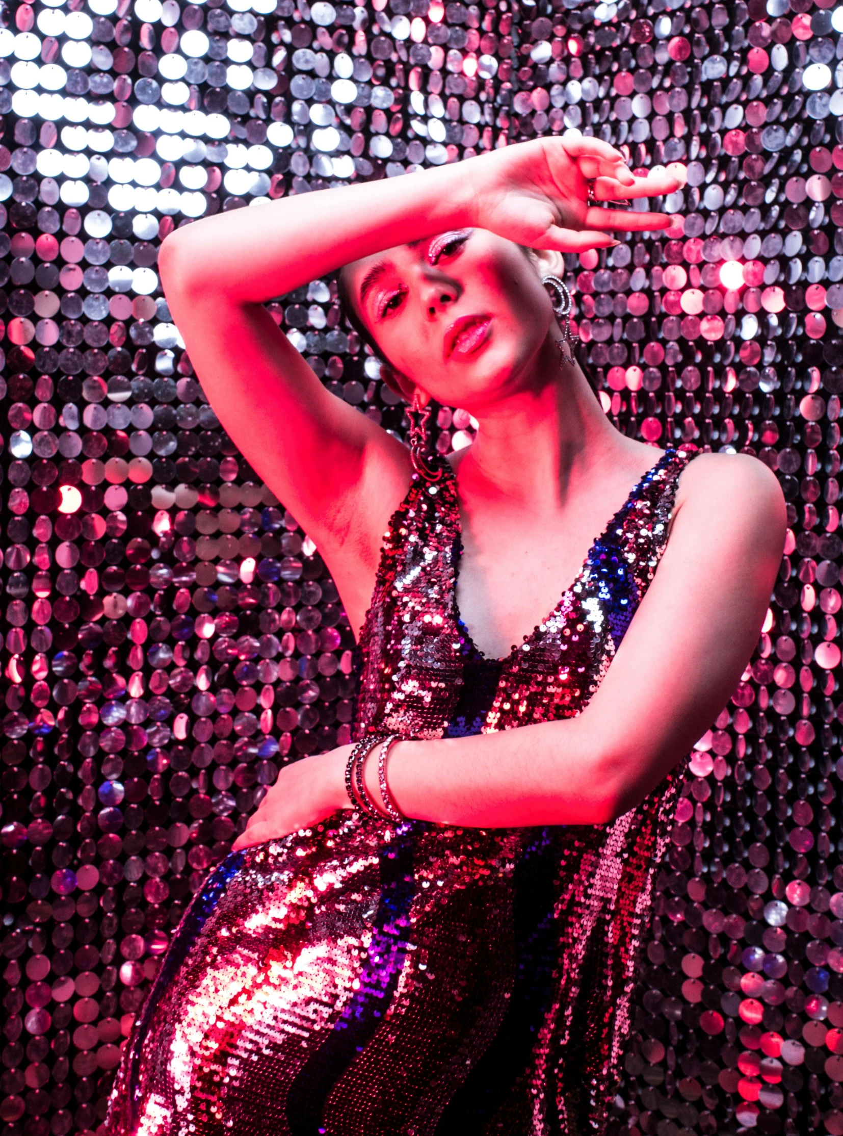 an african american woman in shiny disco dress poses for a studio s