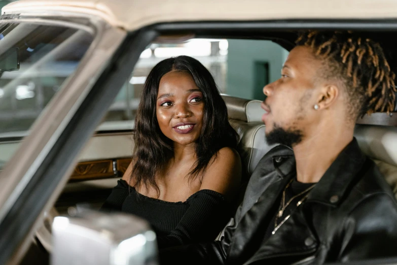 young couple smiling while sitting inside of car