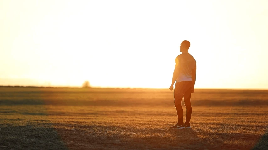 a man is standing in the middle of a field