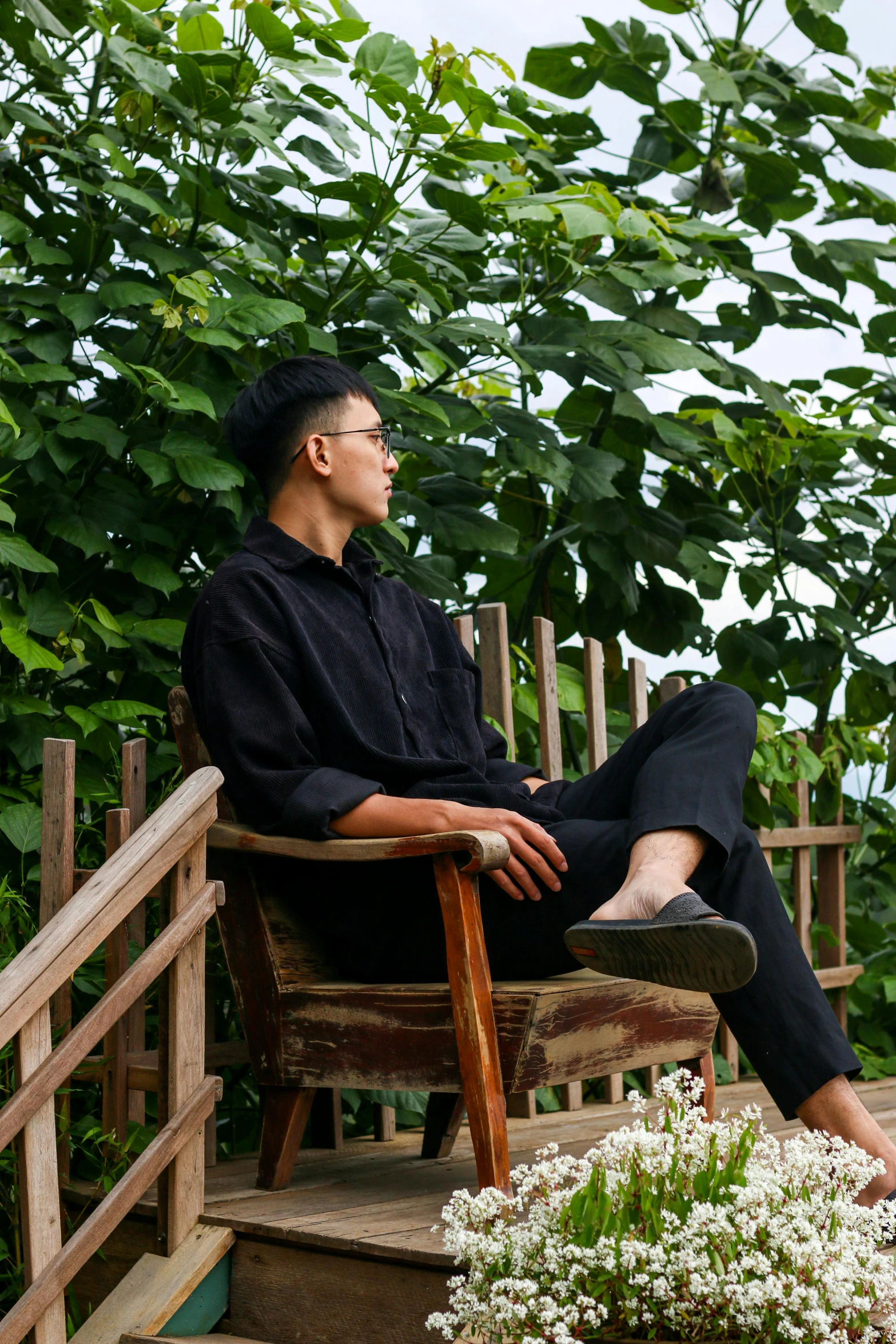 a man is relaxing on a chair at the top of stairs