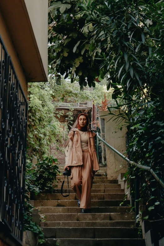 a woman is walking up the stairs wearing a trench coat