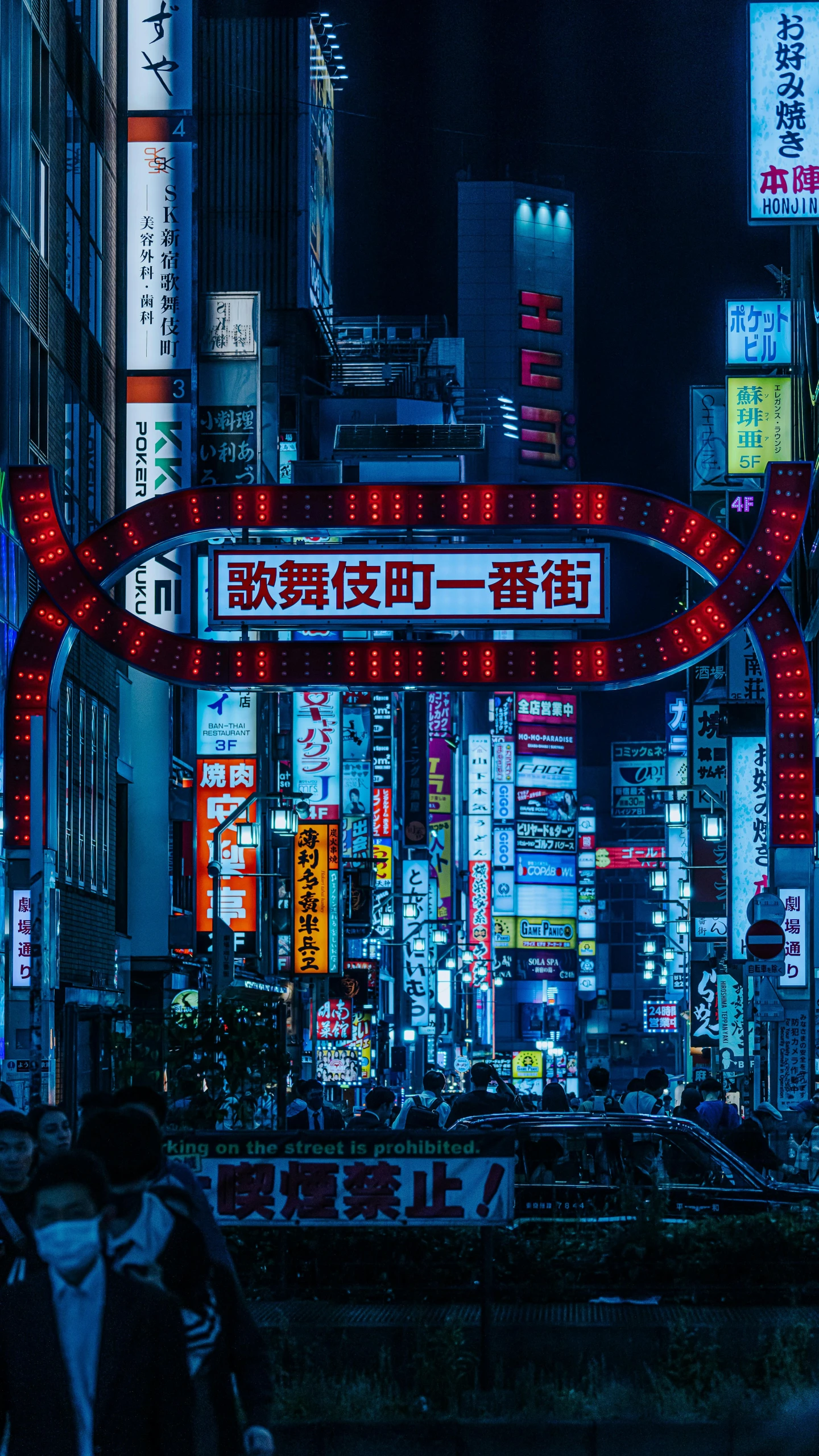 a big neon sign lit up on a crowded street