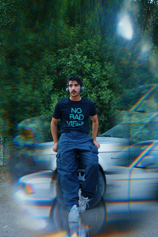 a man standing next to two parked cars