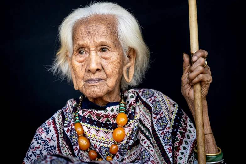 an old woman holding a baseball bat on a black background