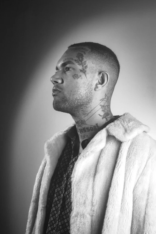 a man in a jacket with tattoos on his arm