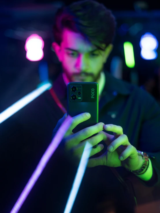 a young man is texting while holding his cell phone