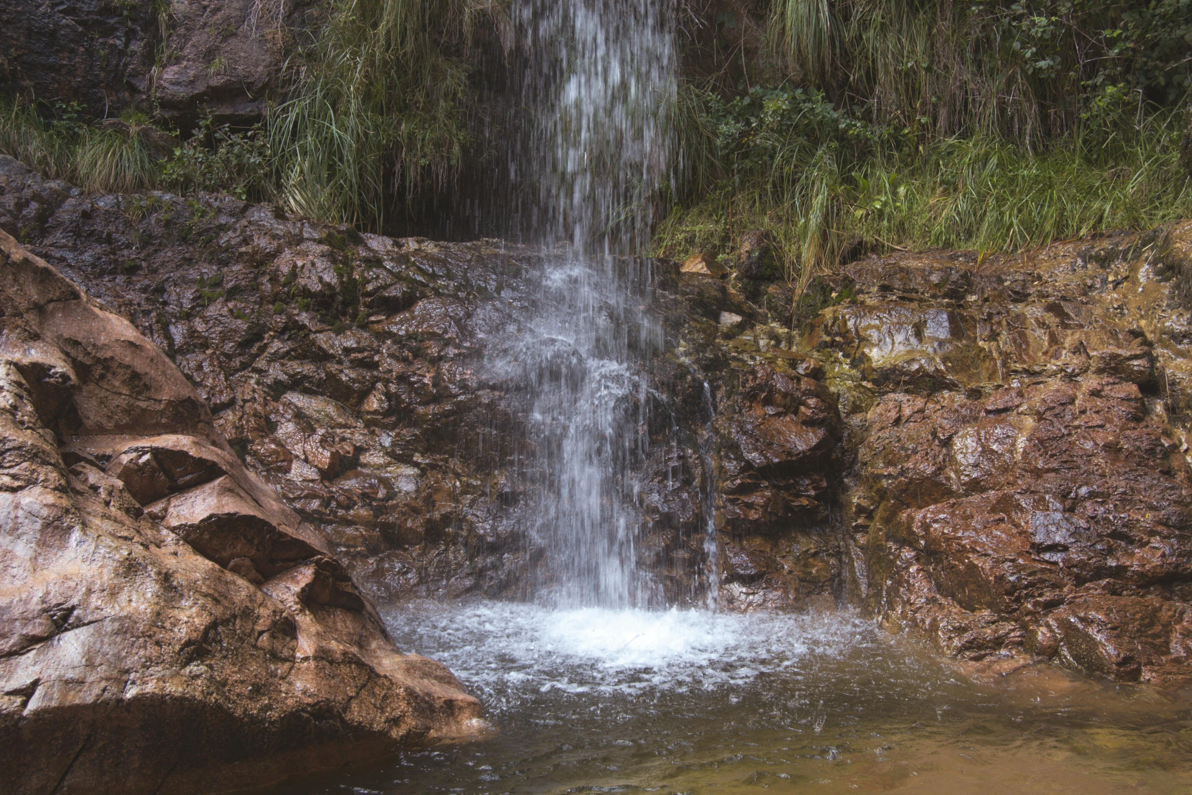 there is a large waterfall that looks like it has some kind of water coming out of the rocks