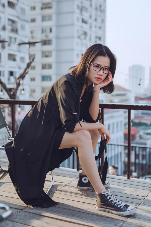 a woman wearing glasses is sitting on a balcony