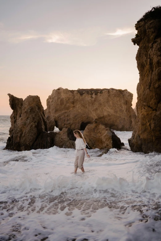 a person holding a baseball bat and standing in the surf