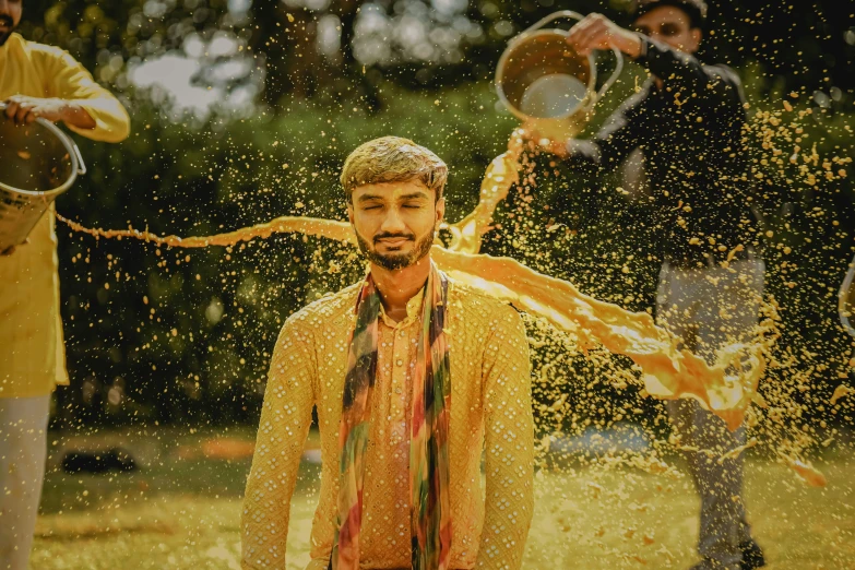 a man with yellow shirt and tie in front of a crowd