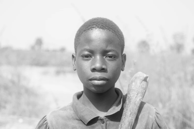 a boy is holding a banana in the field