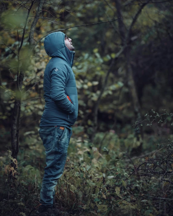 a man is standing outside, in a forest