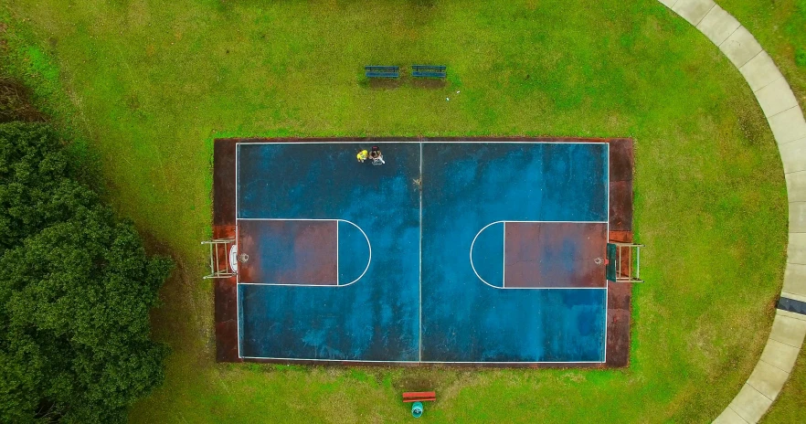 an overhead s of a blue basketball court in a park