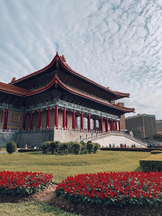 a very tall building near some nice red and white flowers