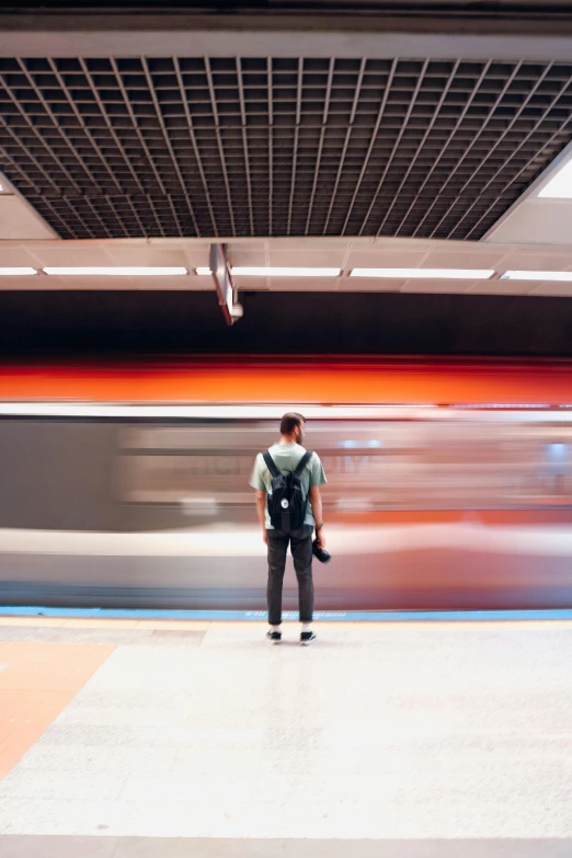 person waiting on platform in subway station and moving train