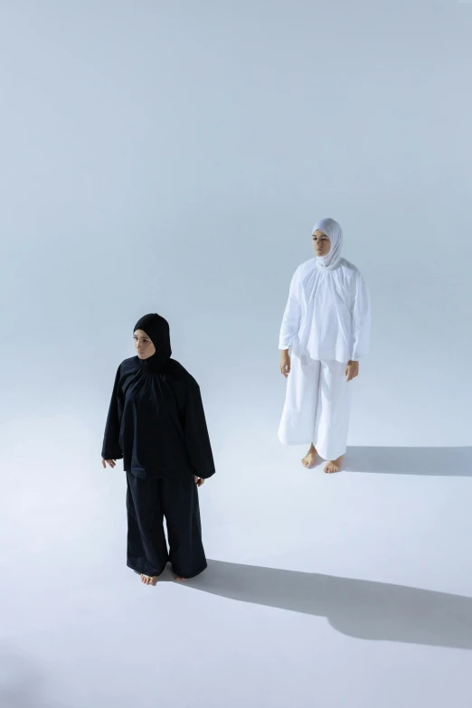 two people are standing in front of a white backdrop