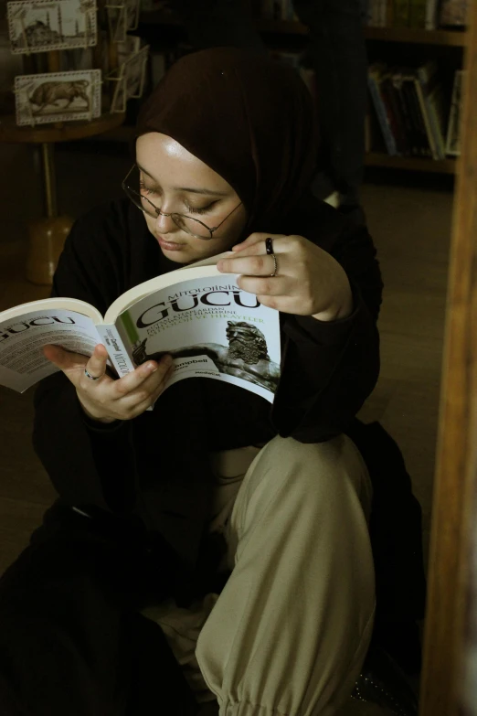 a woman is sitting on the floor reading a book