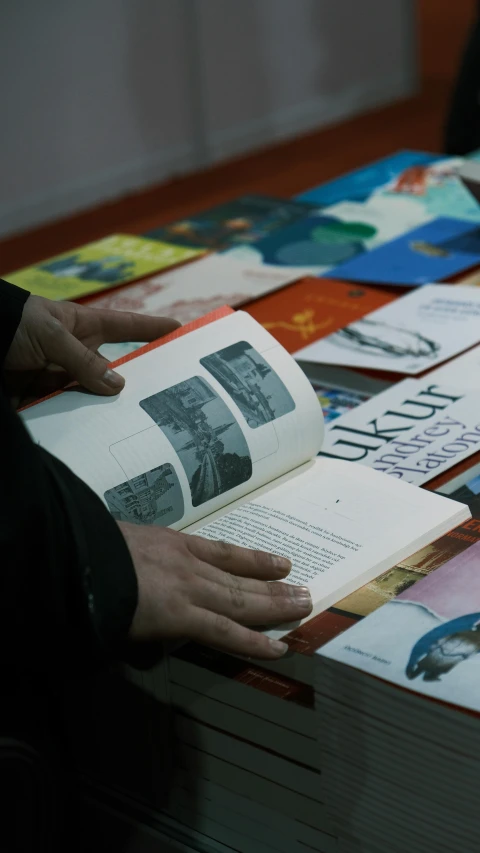 a person reading a book on top of a table