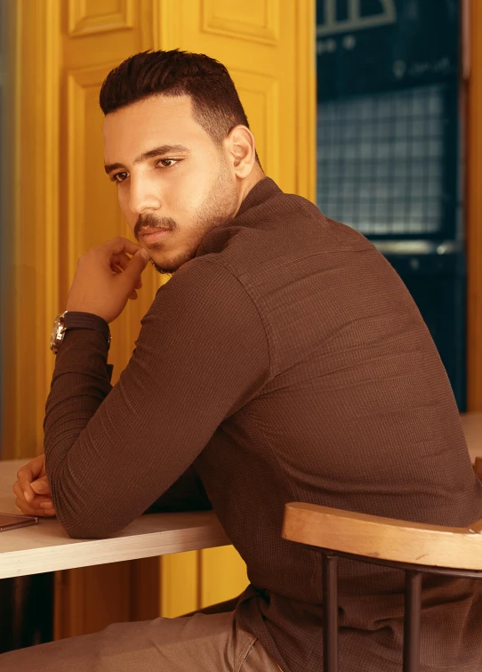 a man sitting on a wooden bench next to a white chair