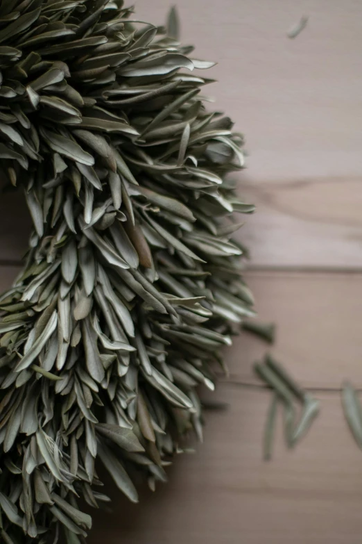 a wreath made from leaves laying on a wooden floor