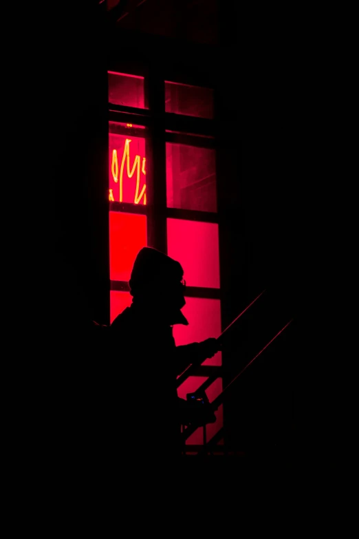 a black silhouette of a man wearing a hat and standing on some steps