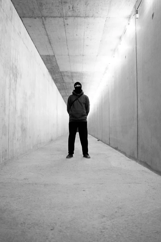 a black and white po of a person standing in a large hallway