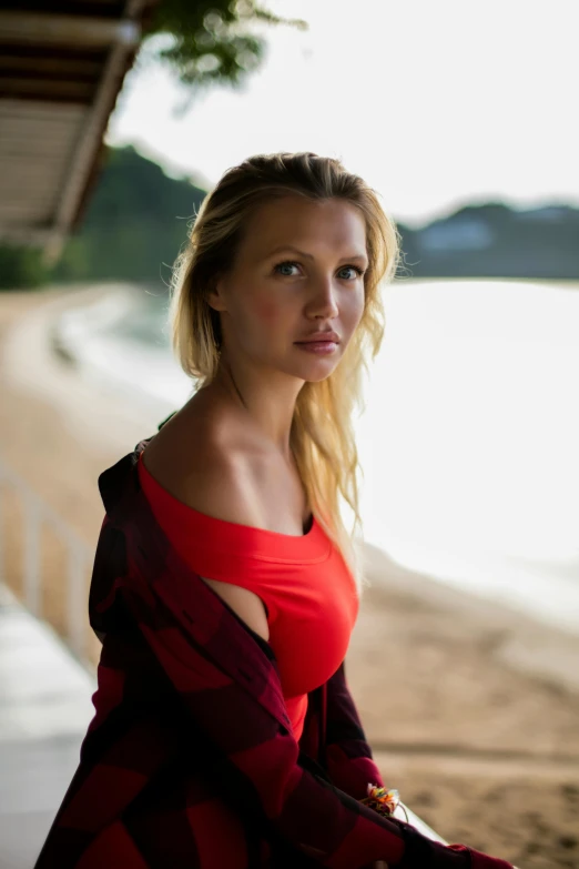 a woman leaning against a wall with her hand on the hips