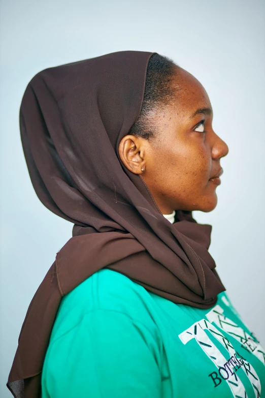 a young woman with an over sized scarf on her head