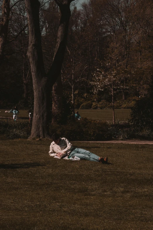 a person laying on the ground with their arms around her head