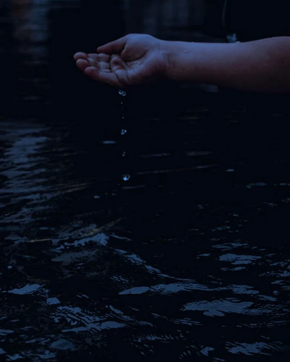 a person is holding out their hand with the water dripping from it