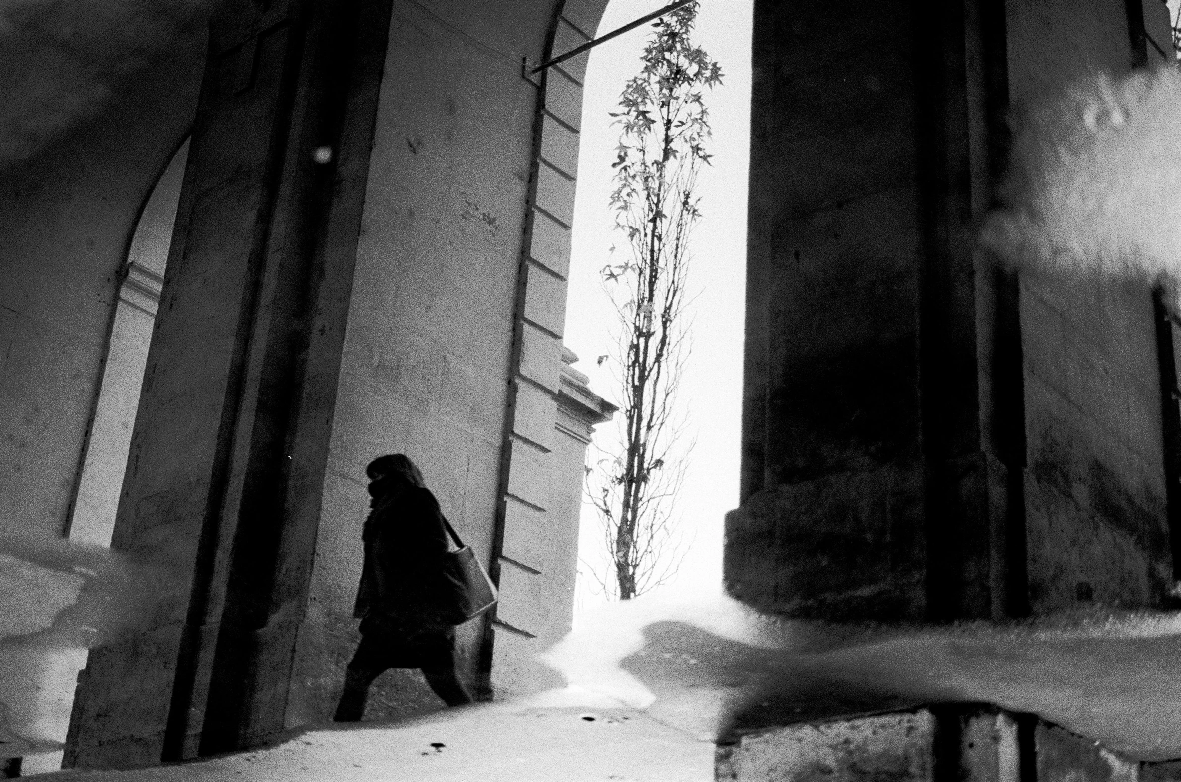 a person walking on a snow covered ground next to a building