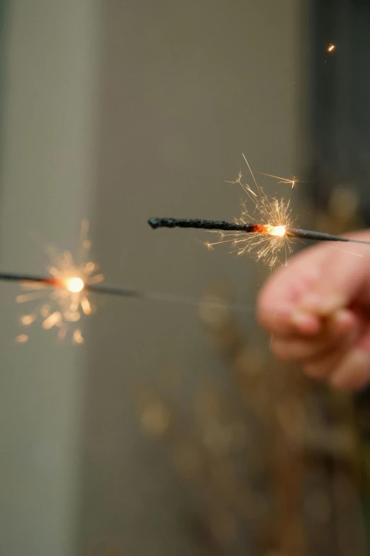 a person holding on to sparklers that have caught on them